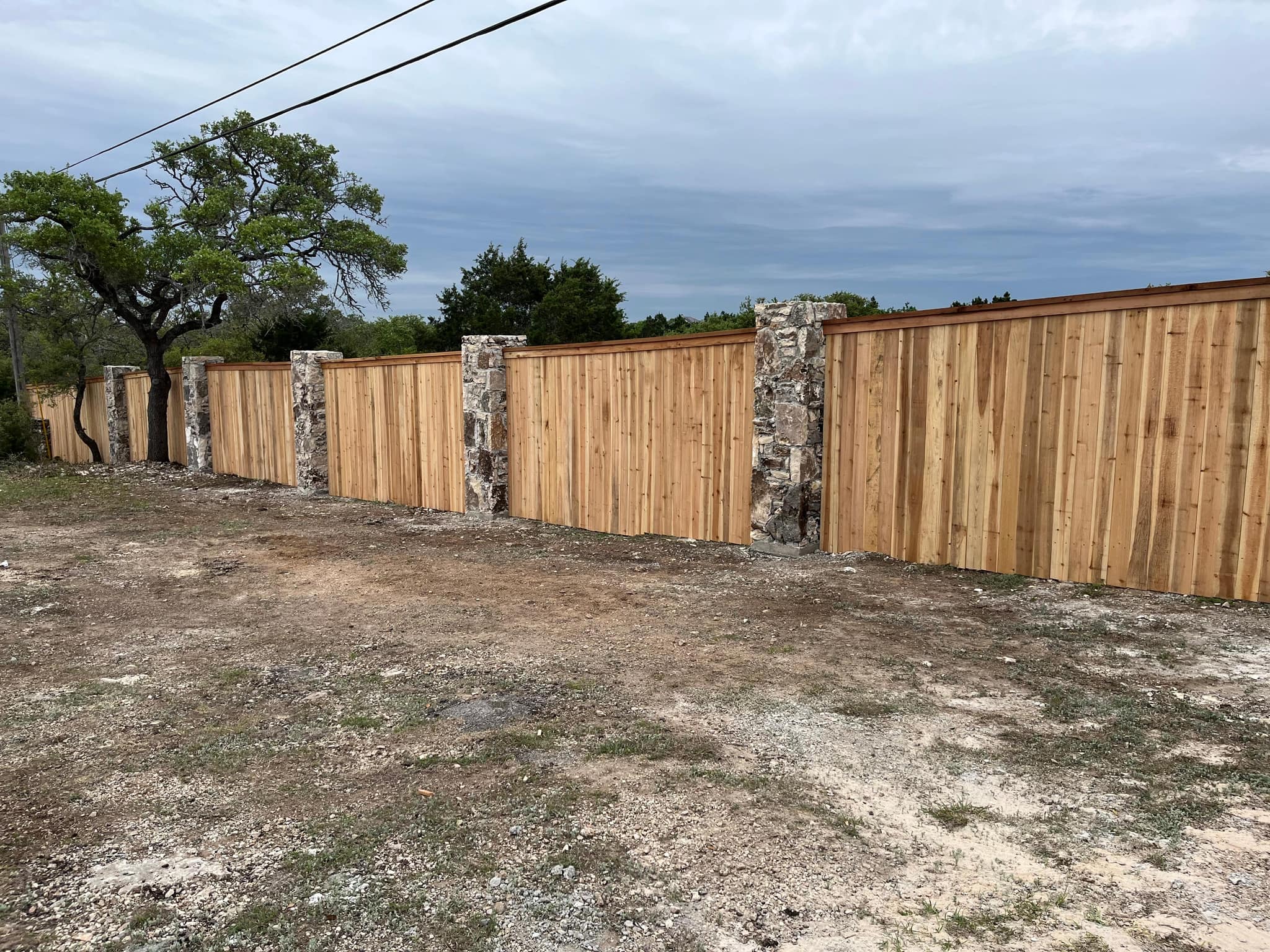 Cedar privacy fence with stone columns between the panels