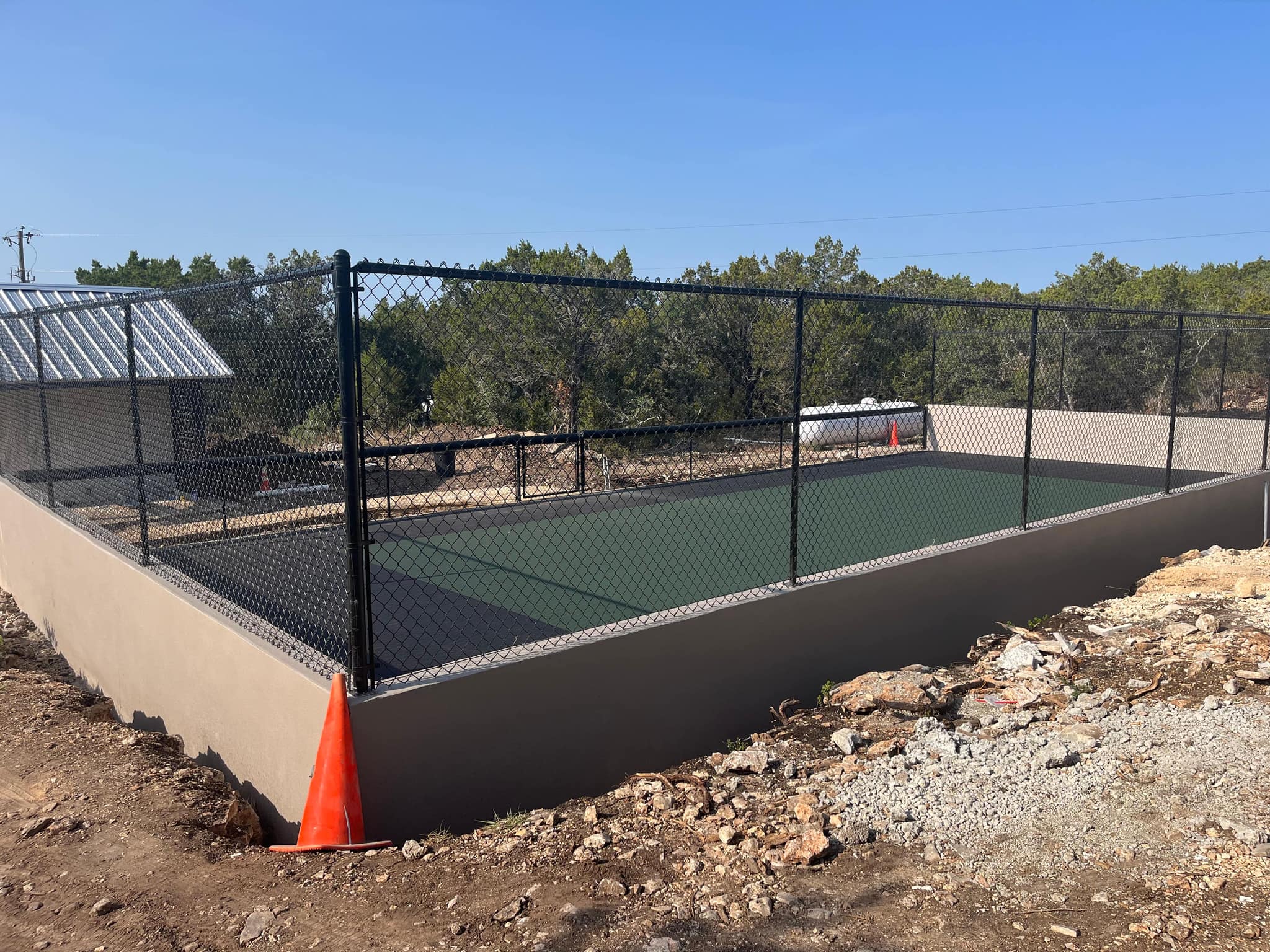 Black chain link fence on a concrete wall around a sport court