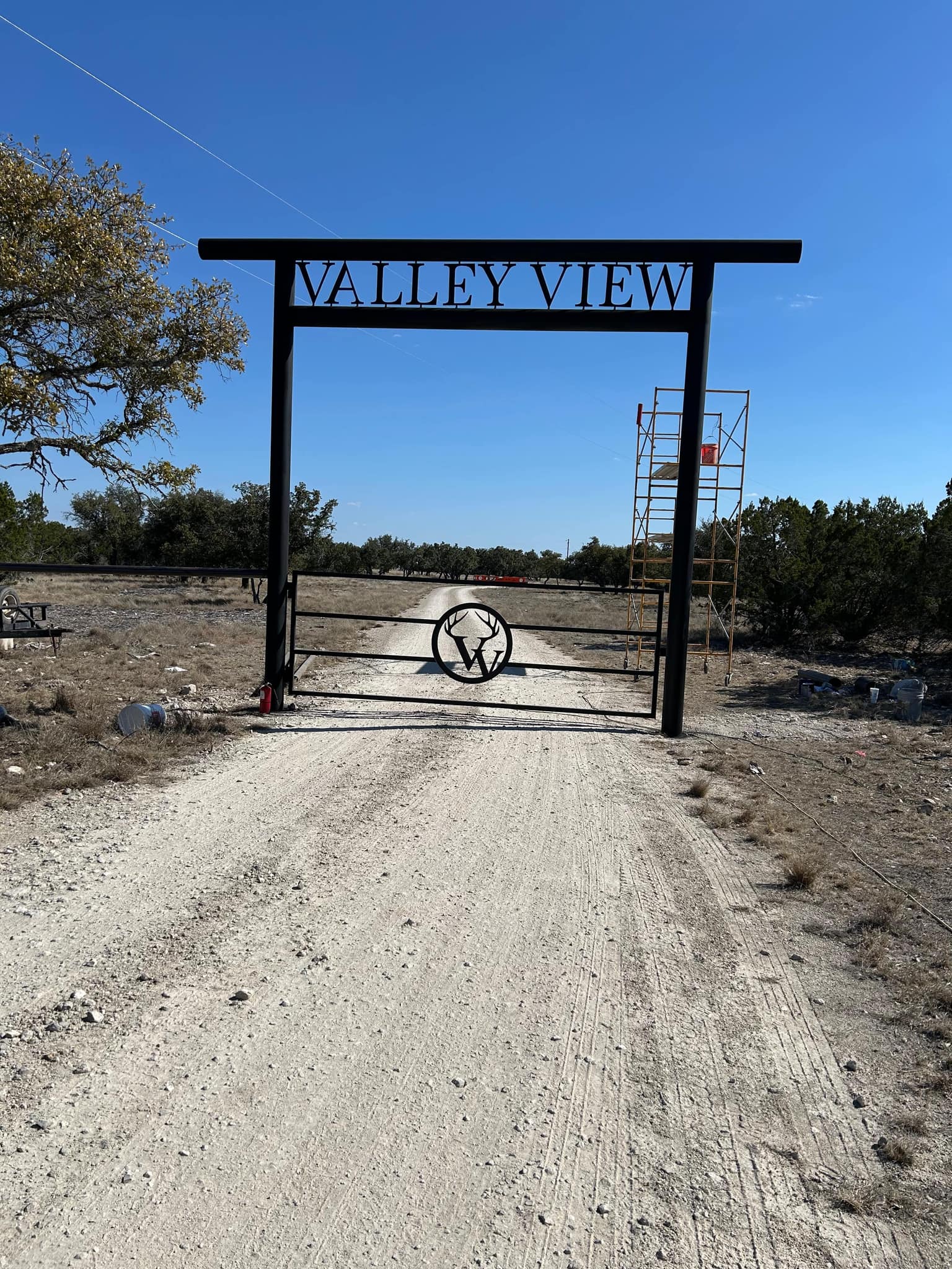 Steel entry arch with the property name over a driveway gate