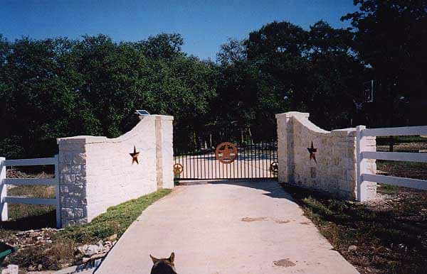 Iron gate in a horse fence between white columns