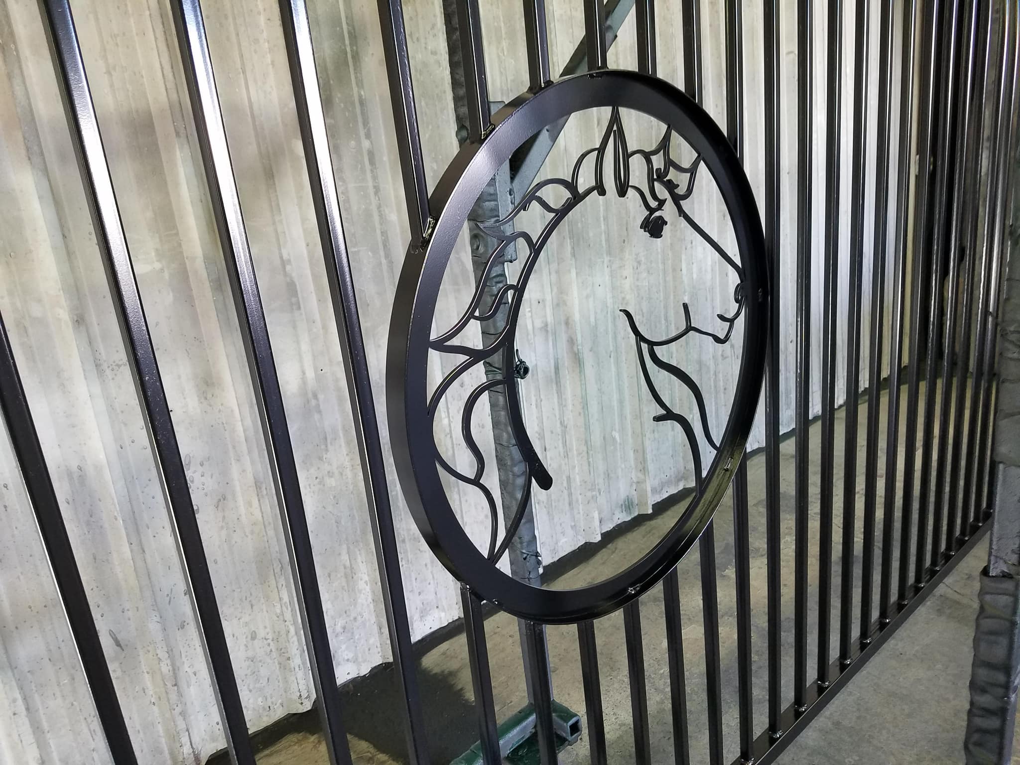 Close-up of a cut-steel horse head medallion in an iron gate