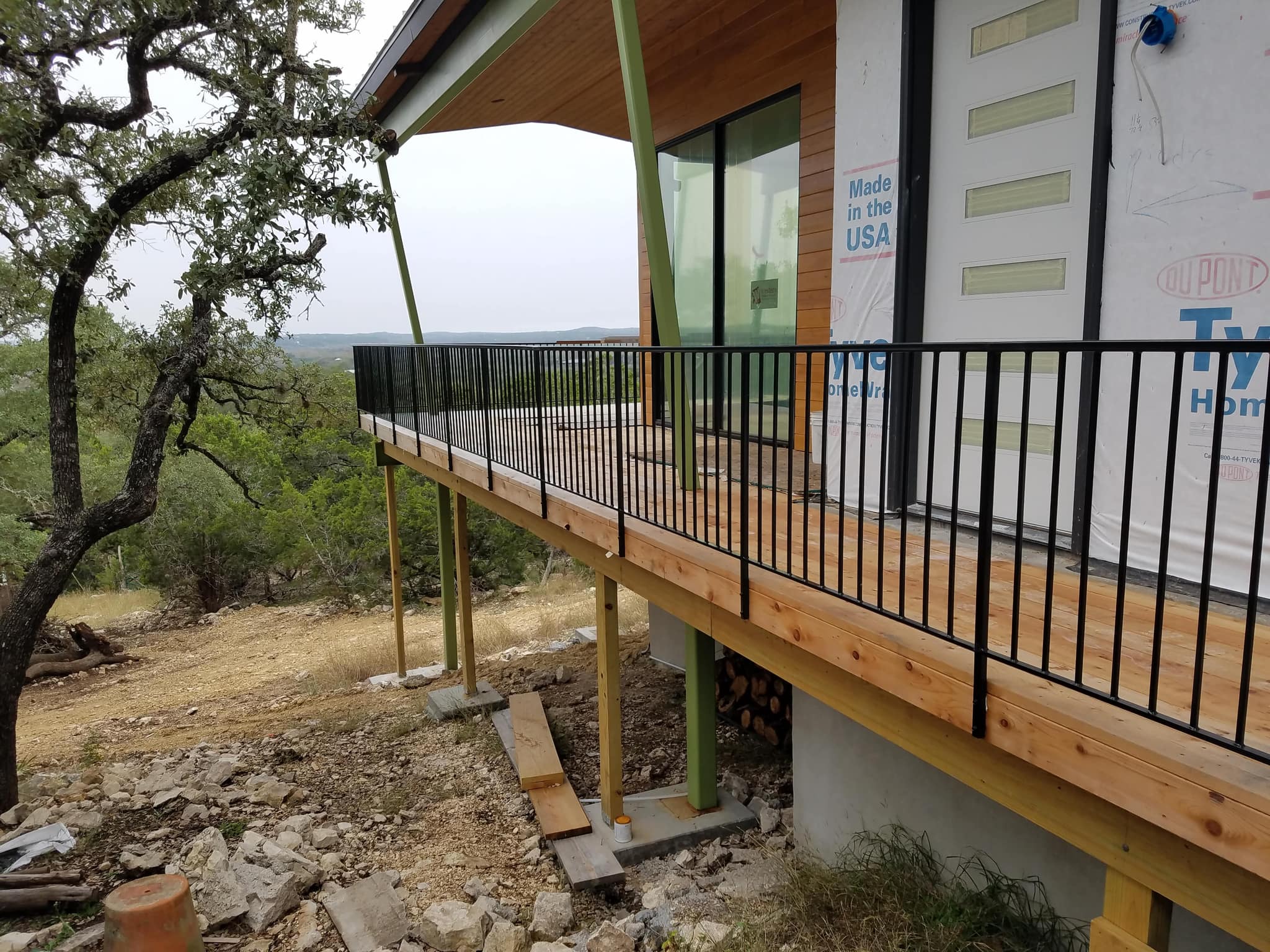 Black iron railing along a raised wooden deck looking out over the hills