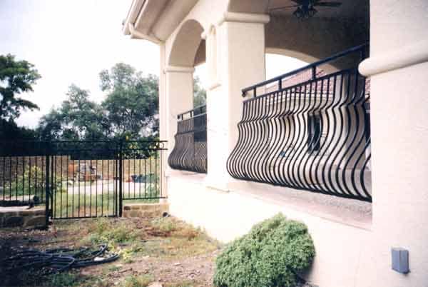 Ornamental iron porch railing on a stucco home