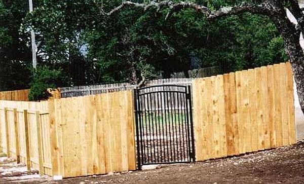 Cedar privacy fence with an arched iron walk gate
