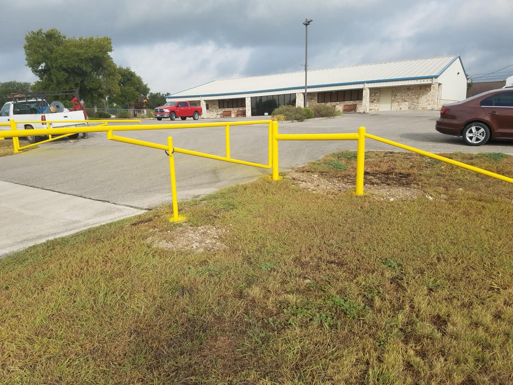 Yellow steel pipe barricade along a commercial lot