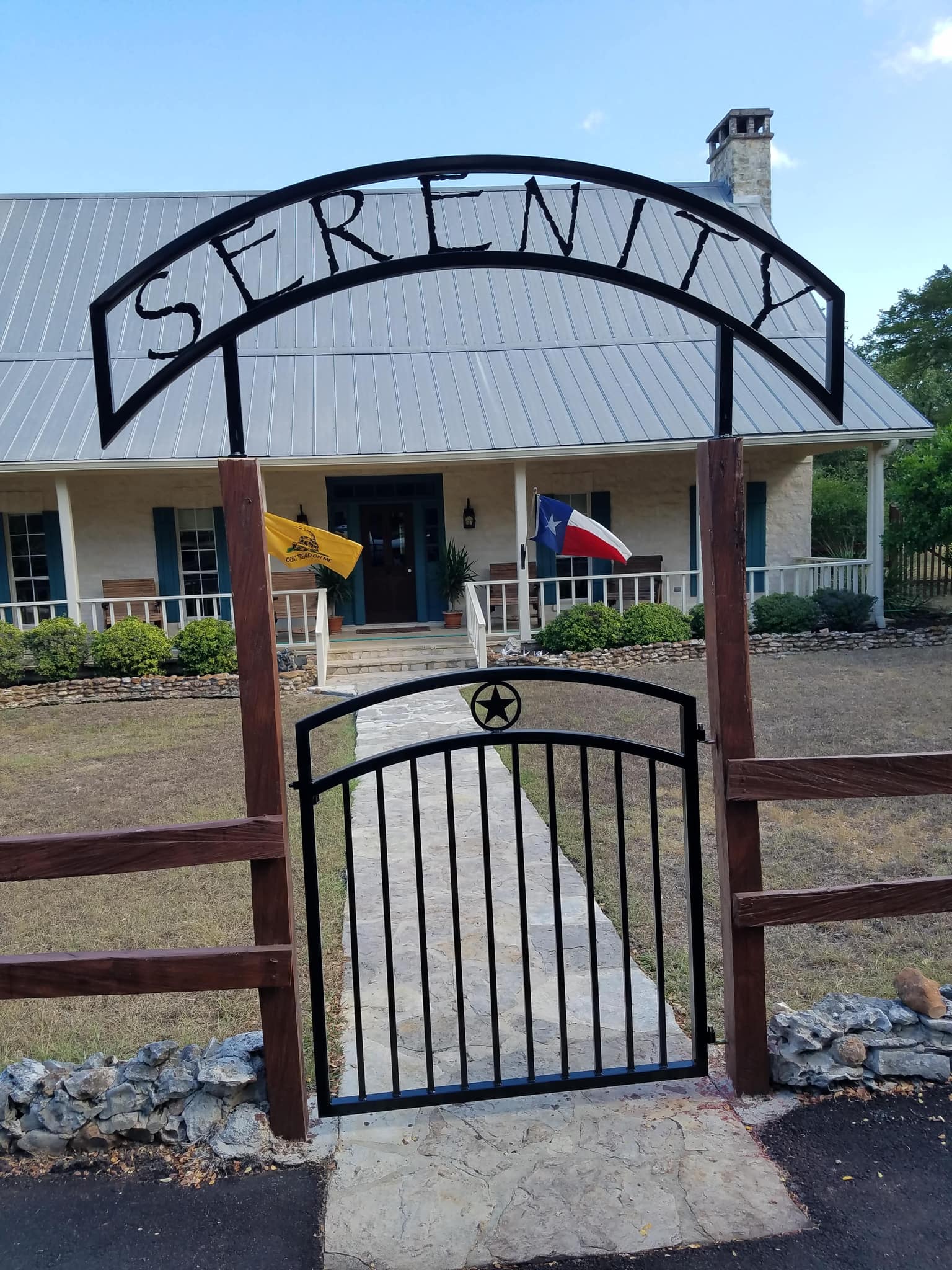Iron name arch reading SERENITY over an iron walk gate with a star