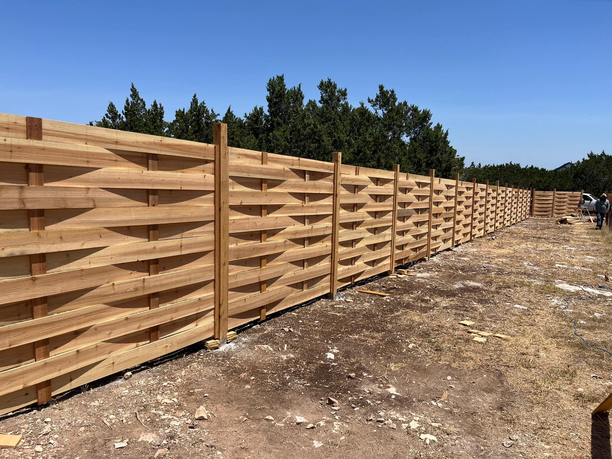 A long run of 6 ft cedar basketweave fence