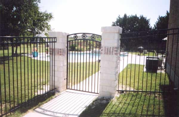 Six-foot black wrought iron fence and gate with limestone columns